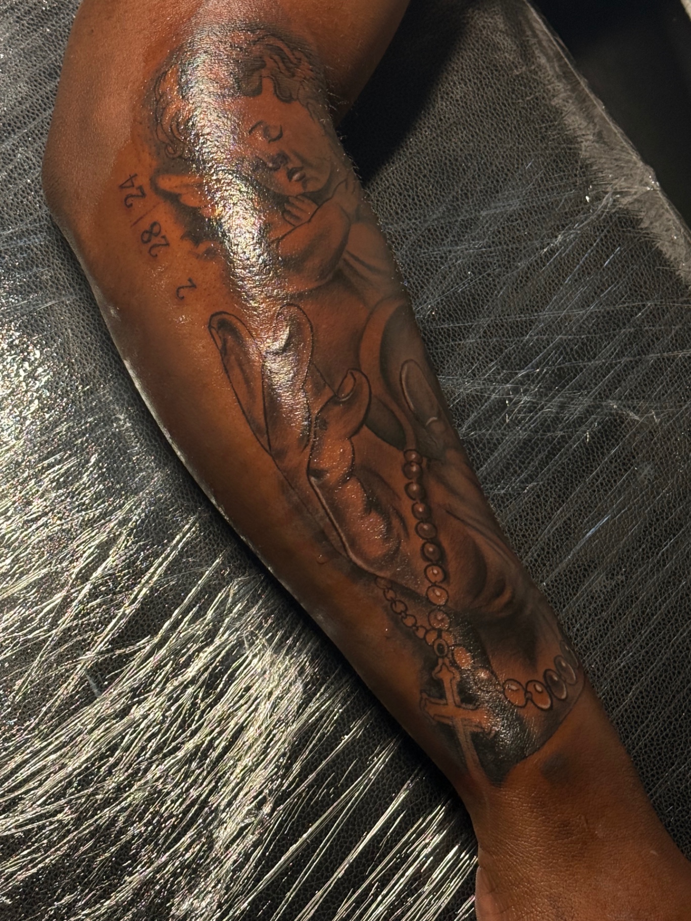Praying hands and cherub tattoo