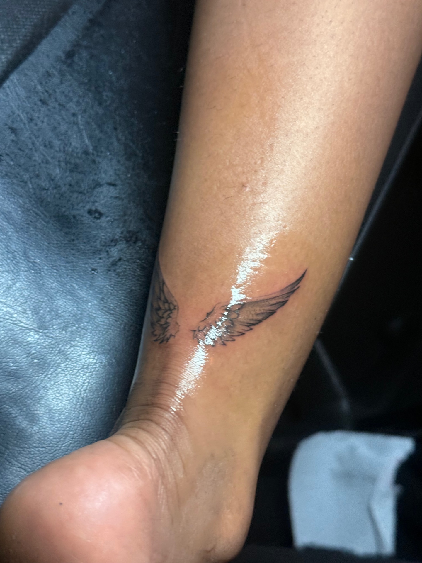Small angel wings ankle tattoo