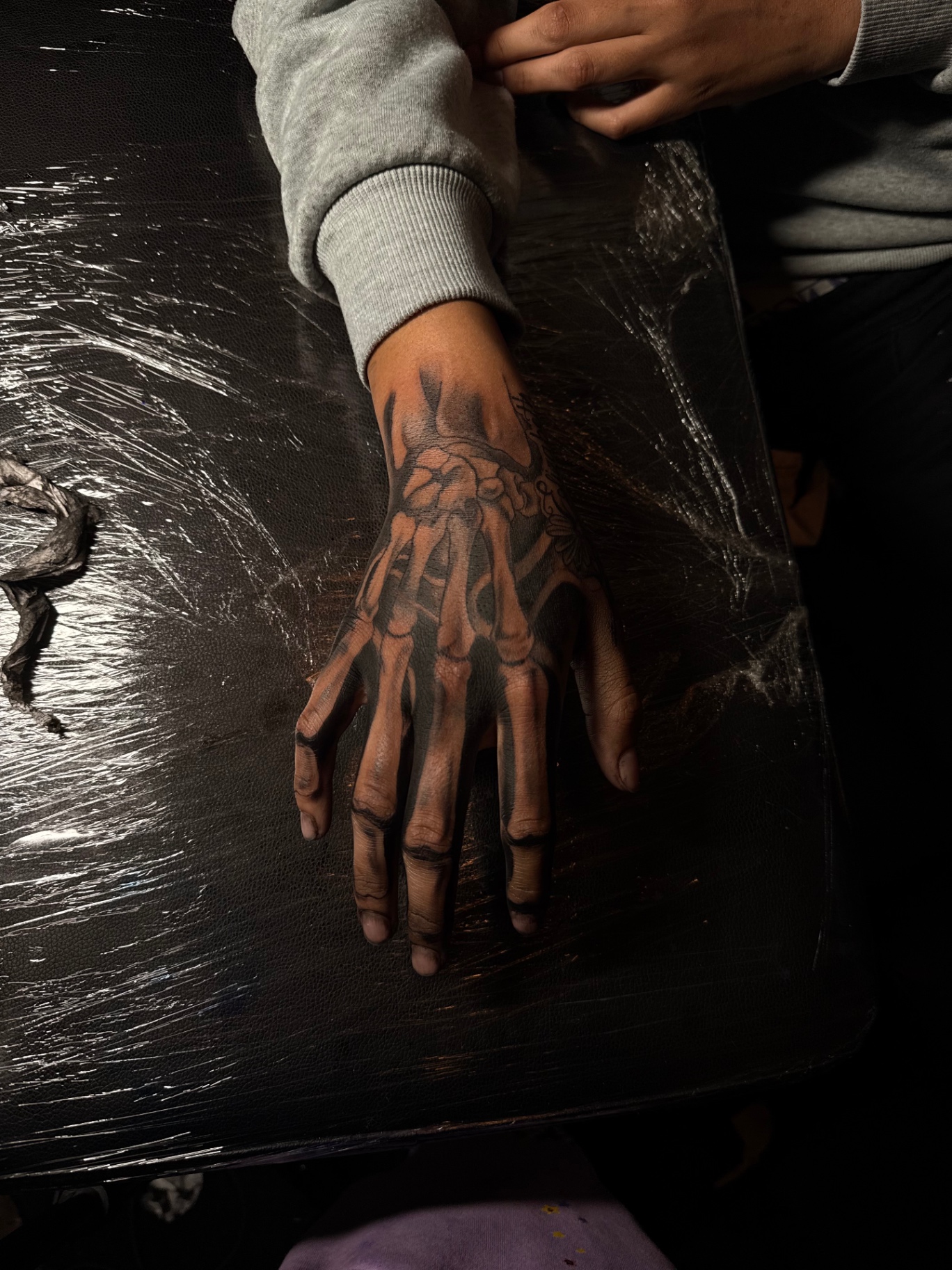 Black and grey skeleton hand tattoo