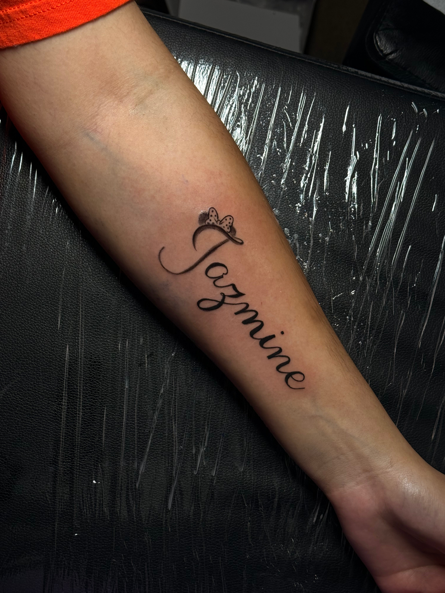 Jasmine script forearm tattoo with butterfly bow